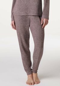 Completo da loungewear marrone mélange composto da una maglietta a maniche lunghe e pantaloni coordinati. Tessuto morbido con una vestibilità comoda; i pantaloni hanno polsini elasticizzati.