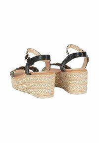 Sandali con zeppa in pelle nera, pianta in juta intrecciata, cinturino alla caviglia regolabile e suola testurizzata per una migliore aderenza. I lati presentano un design intrecciato.