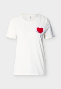 Λευκό κοντομάνικο T-shirt με στρογγυλή λαιμόκοψη, που φέρει μια κόκκινη καρδιά και τη λέξη "AMOUR" στο αριστερό στήθος.