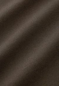 Tissu marron à côtes avec une texture lisse, présentant des variations subtiles de ton et un motif constant sur toute la surface.