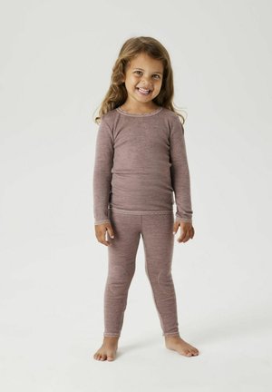 T-shirt thermique à manches longues, teinte rose, associé à un legging assorti. Tissu doux avec des bordures en dentelle au niveau du col et des poignets. Enfant debout pieds nus.