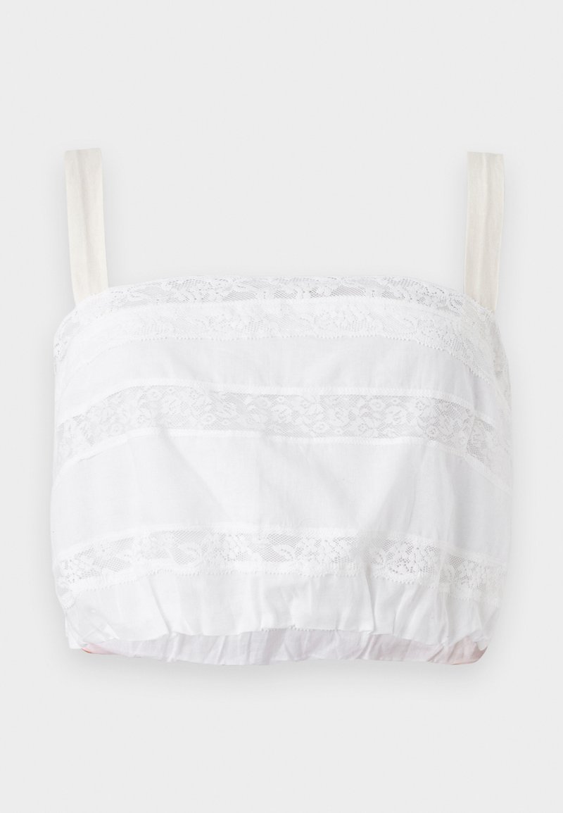 White cropped top with lace detailing, featuring horizontal stripes of fabric and lace trim, adjustable straps, and elasticized bottom hem.