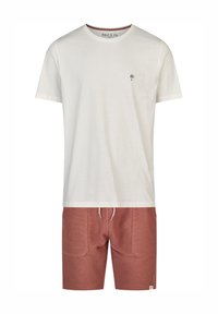 Camiseta de algodón blanca ligera con un pequeño logo de palmera verde, combinada con pantalones cortos texturizados de color óxido con cintura elástica y cordón.