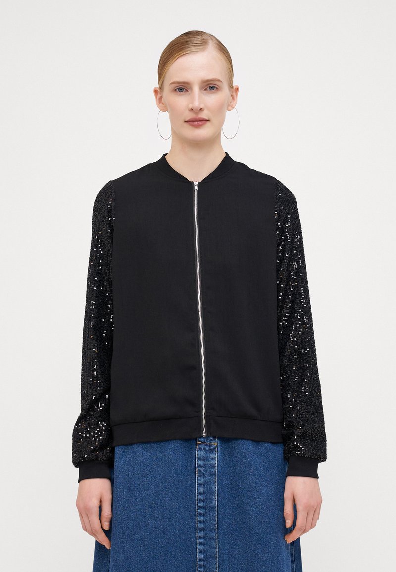 Black bomber jacket with a zip front; main body is smooth fabric, sleeves have textured black sequins. Ribbed cuffs complete the design.