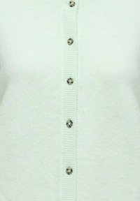 Mátově zelený kardigan z měkké látky, s žebrovanou strukturou a šesti ozdobnými knoflíky se vzorovaným designem po celé přední straně.