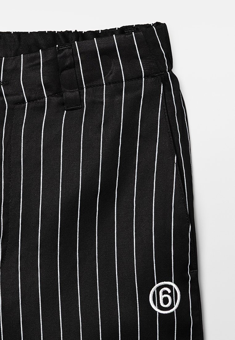 Pantaloni neri a righe, realizzati in tessuto liscio con una vestibilità comoda. Presentano strisce verticali bianche e un logo bianco a forma di cerchio con il numero "6" nella parte anteriore.