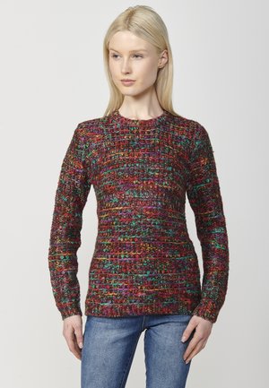 Pull en tricot avec un motif texturé et des fils multicolores rouges, verts et bleus. Col rond et manches longues.