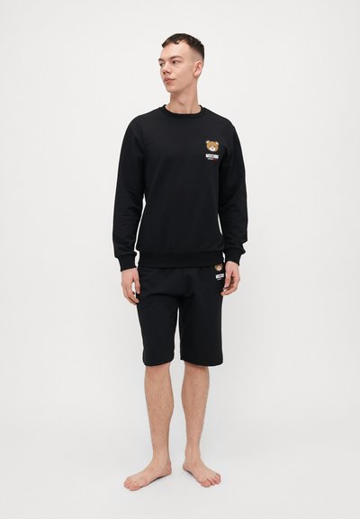 Black cotton sweatshirt and shorts set, featuring a bear logo on the chest and hem. Smooth texture with ribbed cuffs and waistband.