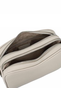 Texturiertes beige Lederhandtasche mit mehreren Fächern, ausgestattet mit silbernen Reißverschlüssen und einem weichen Stofffutter. Innentaschen zur Organisation.