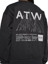 Zwarte sweatshirt met witte berggrafiek en tekst inclusief "ATW", "Off Duty Gear", "All Terrain Wear" en "HALO" op de achterkant.