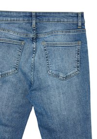 Blaue Denim-Jeans mit einem standardmäßigen Fünf-Taschen-Design, verblasster Textur und kontrastierendem gelbem Nähen entlang der Nähte und Taschen.