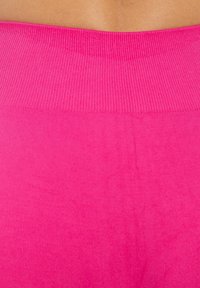 Aansluitende roze leggings met een ribbelband, een gladde textuur en een effen kleur ontwerp. Geen zichtbare patronen of hardware.