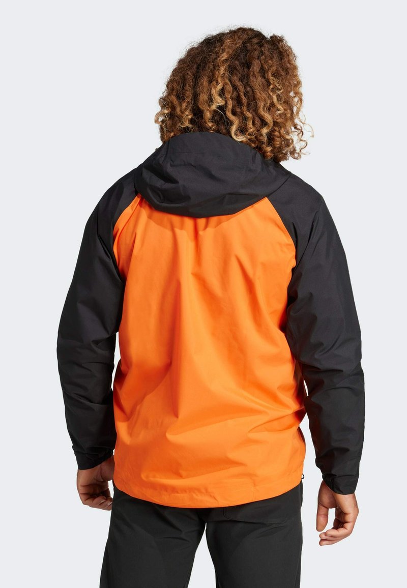 Orange og sort vandafvisende jakke med hætte, der har et strømlinet design, glat tekstur og kontrasterende farveblokering på ærmerne.