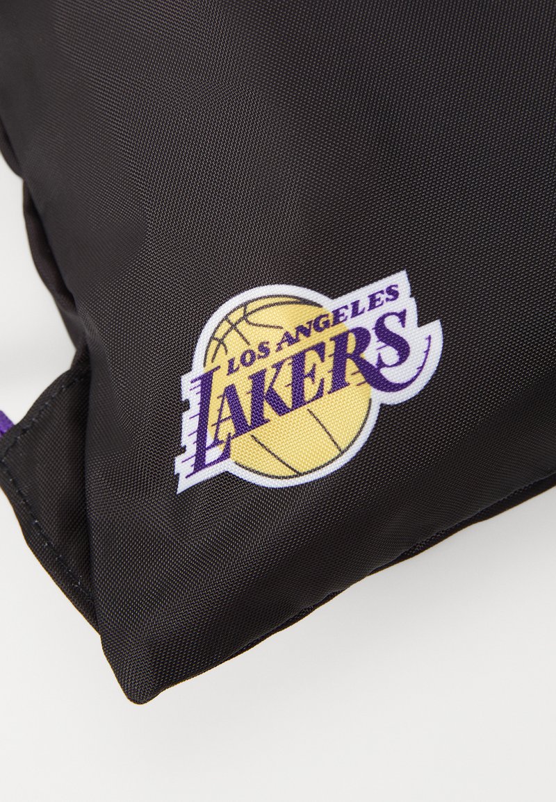 Bolsa de nailon negra con un logo de Los Angeles Lakers en amarillo y púrpura, con un diseño de baloncesto y lettering bordado.