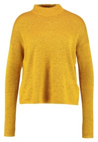 Jersey amarillo de punto con cuello alto, mangas largas y un ajuste holgado. La textura parece suave y ligeramente texturizada.