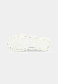 Biała gumowa podeszwa sportowa z teksturowanym wzorem logo, posiadająca rowkowane krawędzie dla lepszej przyczepności oraz gładką powierzchnię zapewniającą trakcie.