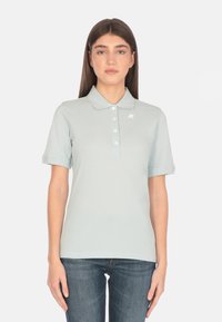 Polo di colore azzurro chiaro realizzato in tessuto morbido, con colletto classico, pattina con cinque bottoni e logo bianco sul lato sinistro del petto.