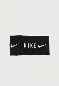Μαύρη κορδέλα Nike με λευκά λογότυπα Nike Swoosh και στις δύο άκρες και το κείμενο «NIKE» στο κέντρο.
