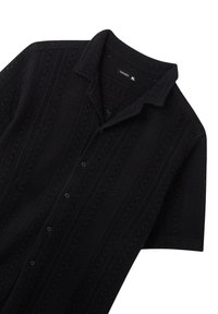 Camicetta nera a maniche corte con motivo a maglia testurizzata, colletto e chiusura con bottoni, realizzata in materiale traspirante e con vestibilità rilassata.
