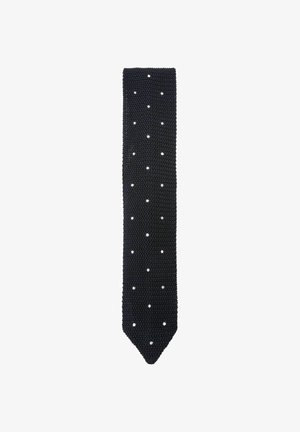 Schwarze gestrickte Krawatte mit gleichmäßig verteilten kleinen weißen Punkten und einer spitzen Spitze auf weißem Hintergrund.