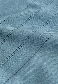 Tissu bleu clair avec un tissage texturé, présentant des points diagonaux et une surface lisse. Comprend un léger éclat et de la profondeur.