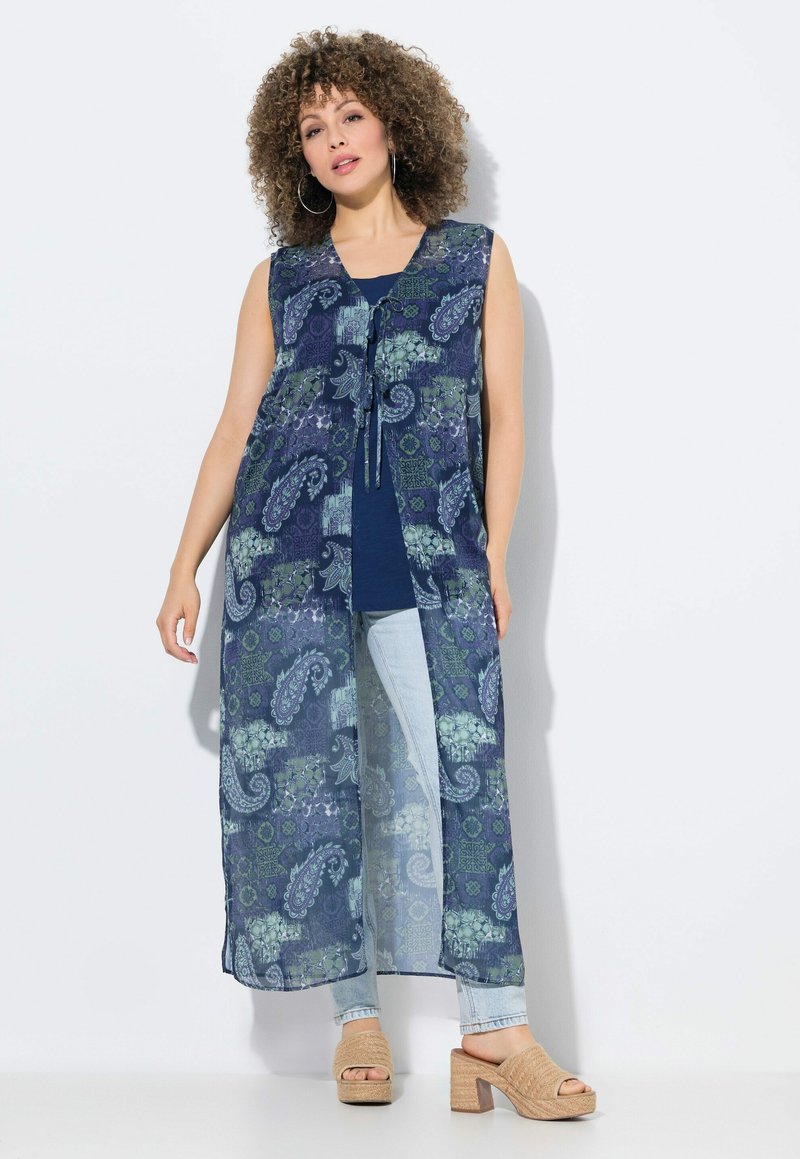 Dlouhý, bezrukávový, námořnický kimono s paisley vzorem v zelených a modrých tónech, s upevněním na krku a průhlednou látkou.
