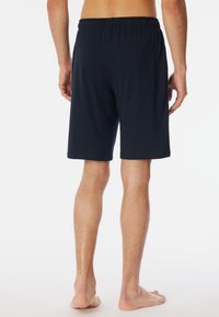 Navy blue shorts made of soft fabric, featuring an elastic waistband and a relaxed fit. Smooth texture with no visible patterns or accents.