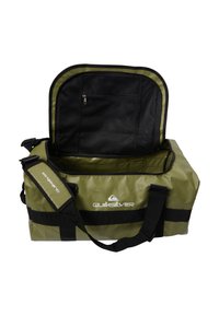Grön duffelväska med vattentålig yta, svarta detaljer, dragkedjestängning på toppen, avtagbar rem och inre meshnätsk pocket. Quiksilver-logotypen synlig.