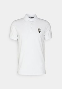 Hvit polo skjorte laget av bomull, med en svart grafikk av en figur med solbriller på venstre bryst. Klassisk krage med tre knapper.