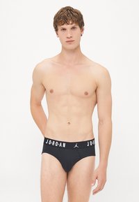 Schwarze Herrenunterhosen mit einem in Weiß auf dem Bund aufgedruckten Jordan-Logo; glattes Material, enganpassende Passform und minimalistisches Design.