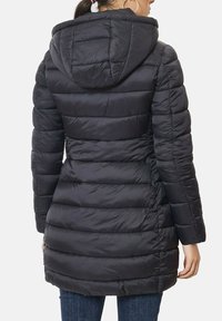 Manteau rembourré noir avec capuche, présentant un design matelassé et des poignets élastiques. Le matériau semble lisse et léger avec une coupe à la taille.