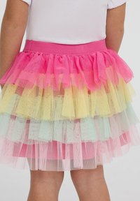 Gonna in tulle con multiple strati arricciati nei colori rosa, giallo e menta, dotata di una vita elasticizzata per una vestibilità comoda.