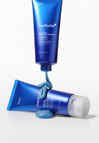 Blaue Plastikschläuche der Medicube Zero Pore Blackhead Mud Maske. Ein Schlauch steht aufrecht mit herausquellendem Produkt, der andere liegt flach.