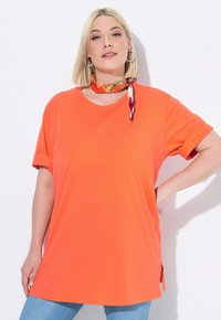 Bright orange T-shirt with rolled short sleeves, round neckline, and side slits. Smooth, lightweight fabric is casual and comfortable.