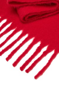 Sciarpa in lana rossa con una texture morbida, bordi sfrangiati e un design piegato. Il materiale appare spesso e caldo, adatto per il clima freddo.