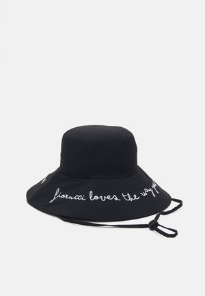 Černý klobouk typu bucket vyrobený z bavlny, s širokým okrajem a bílým vyšívaným textem "fiorucci miluje způsob, jakým ty". Součástí je nastavitelné lanko na bradu.