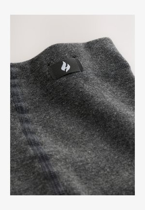 Țesătură gri din material textil cu suprafață texturată, linie de cusătură vizibilă și o etichetă neagră cu un logo alb pe margine.