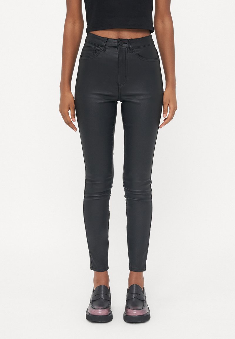 Zwarte high-waisted neplederen broek met een getailleerde pasvorm, gladde textuur en klassiek vijf-pocket ontwerp. Gladde afwerking en gestikte details.