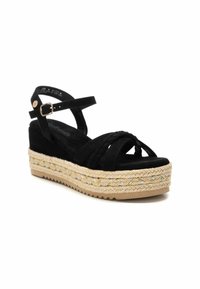 Sandalo wedge in suede nero con cinturini intrecciati, cinturino alla caviglia regolabile e soletta in juta intrecciata con accenti multicolori.