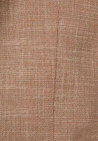 Gestructureerde stof in warme bruintinten met een geweven patroon. Het oppervlak lijkt iets ruw met variërende tinten die diepte toevoegen.