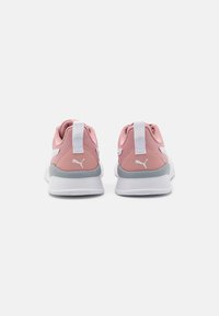 Scarpe da ginnastica rosa con tomaia in tessuto testurizzato, dettagli bianchi, una sezione del tallone di un grigio chiaro e linguette sul retro per una facile vestizione.