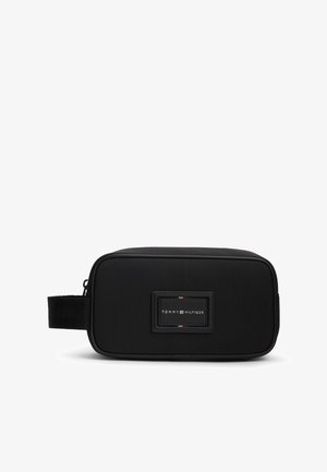 Czarna prostokątna kosmetyczka z boczną rączką i naszywką z logo Tommy Hilfiger na środku przedniej strony.