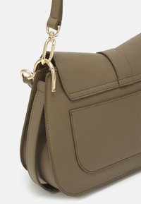 Oliivivihreä nahkainen olkalaukku, jossa on kultaketju, suorakulmainen muoto, kuvioitu pinta ja etutasku.