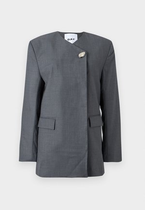 Grijze blazer met een textuurrijke afwerking, voorzien van een diagonale sluiting, een uniek metalen accent en twee klepzakken aan de voorkant.