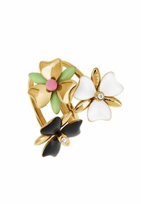 Anello dorato con tre design floreali colorati: nero, bianco e verde con un centro rosa; include un piccolo dettaglio in pietra trasparente.