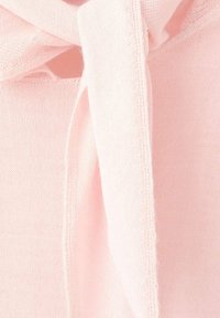 Tessuto rosa chiaro con una texture liscia e un dettaglio a fiocco, caratterizzato da un piccolo apertura vicino al collo. Motivo di cucitura uniforme visibile.