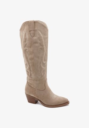 Botte de cowboy haute en daim beige avec des décorations en surpiqûres et un talon empilé en bois.