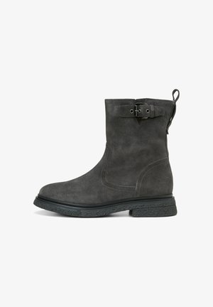 Bottine en daim gris avec un bout rond, détail de boucle sur le côté et une semelle en caoutchouc noir texturé. Texture lisse avec des coutures contrastées.