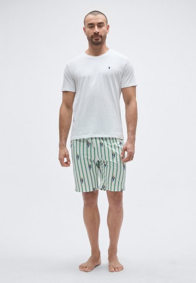 Fehér pamut rövid ujjú póló kis logóval, zöld csíkos úszónadrággal, amely kis, színes mintákat tartalmaz.