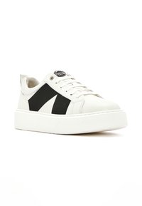 Baskets en cuir blanc avec des accents en tissu noir, bout rond, épaisse semelle blanche, design à lacets et détail de logo circulaire sur la languette.